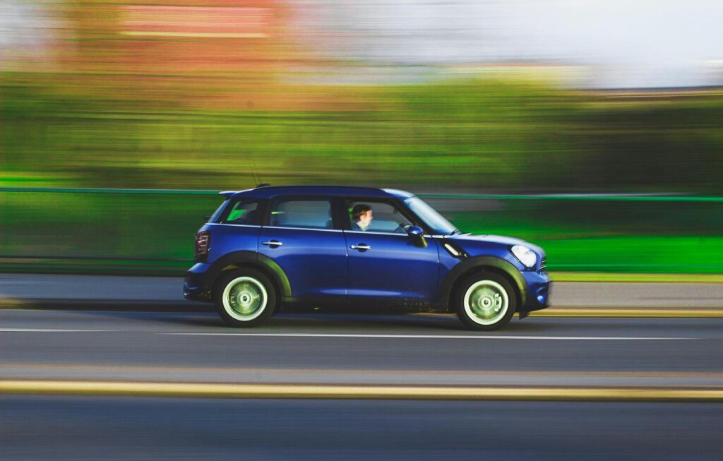 A blue car moving at high speed with motion blur, demonstrating acceleration and Newton’s Second Law in everyday driving.